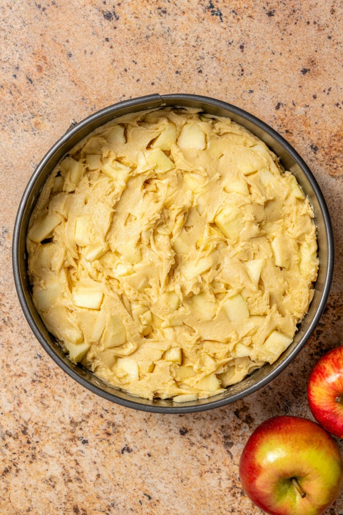 Spreading out the batter in the greased cake pan. 