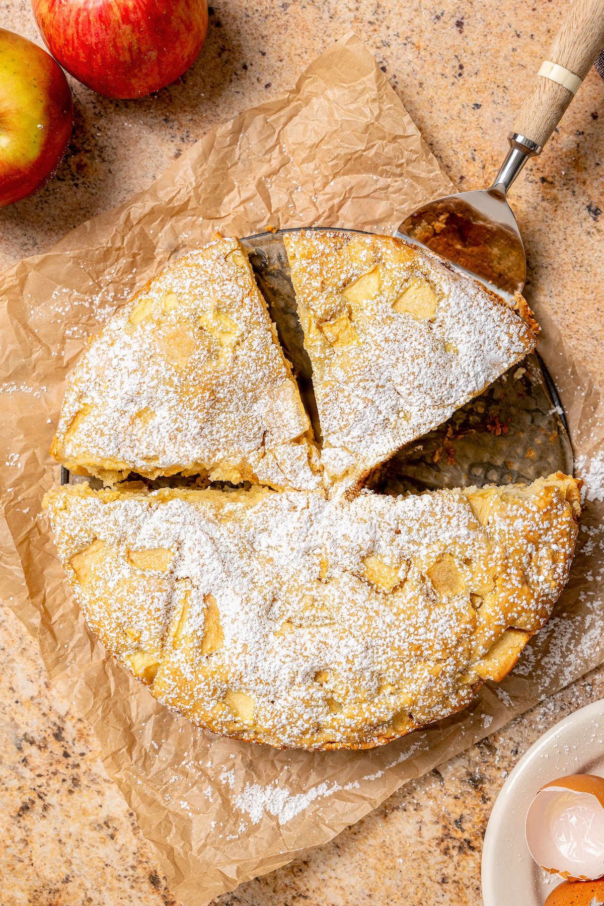 Grabbing a slice of fruity cake with powdered sugar on top. 