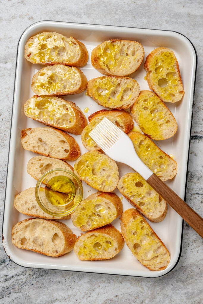 Brushing the bread with olive oil. 