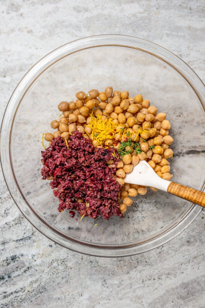 Adding the chickpea mixture ingredients to a bowl. 