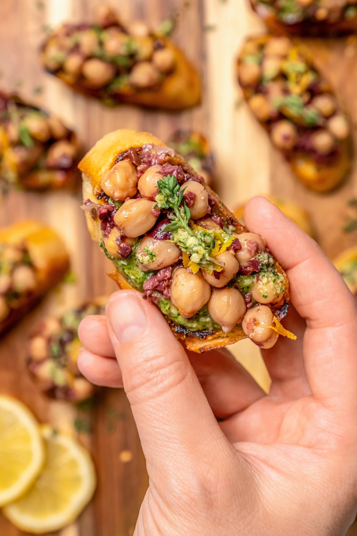 Grabbing a bruschetta with tangy olive-chickpea mixture on top. 