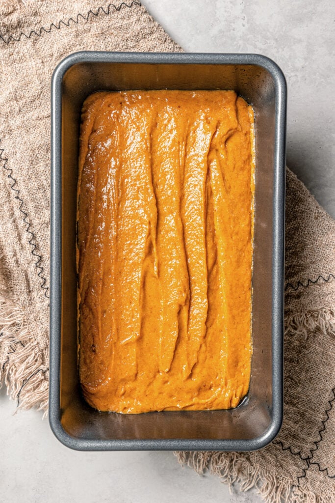 Pumpkin bread batter in the prepared loaf pan. 