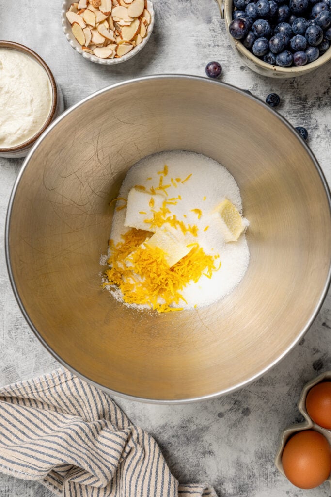 Adding the lemon zest, sugar, and butter to a bowl. 