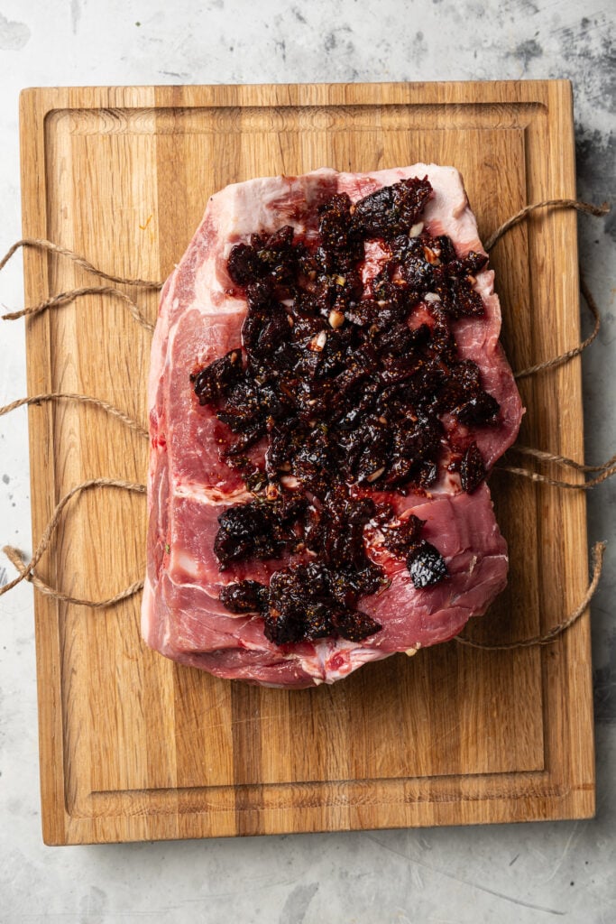 Spreading the garlic-fig mixture on the pork. 