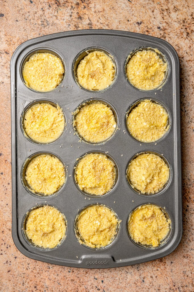 Pouring batter into the muffin tray. 