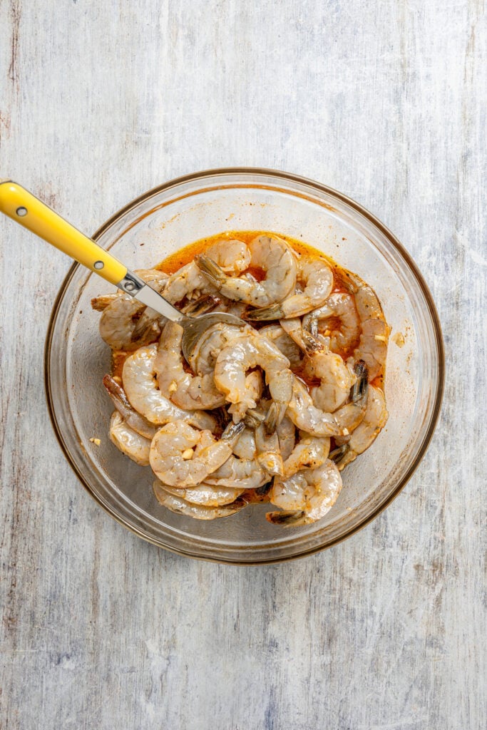 Mixing the shrimp with the marinade. 